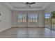 Bright living room with tile floor, ceiling fan, and sliding glass doors with a view of the backyard at 5814 Stockport St, Riverview, FL 33578