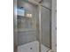 Framed shower featuring gray tile, a glass door, a handheld sprayer, and grab bar at 5814 Stockport St, Riverview, FL 33578