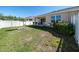 Spacious backyard with a white fence, green grass, landscaping and covered patio, perfect for outdoor entertaining at 7869 Timberview Loop, Wesley Chapel, FL 33545