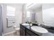 Bright bathroom with double vanity, dark cabinets, large mirror, and tiled floors at 7869 Timberview Loop, Wesley Chapel, FL 33545