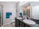 Bathroom with double sinks, a stone countertop, and a glass enclosed shower stall at 7869 Timberview Loop, Wesley Chapel, FL 33545