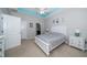Bedroom features a neutral color scheme, teal accents, plush carpet, and an adjoining ensuite bathroom at 7869 Timberview Loop, Wesley Chapel, FL 33545