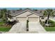 Charming attached home with a two-car garage, beautiful landscaping, and a well-maintained driveway at 7869 Timberview Loop, Wesley Chapel, FL 33545