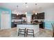 Modern kitchen featuring stainless steel appliances, black cabinetry, an island with bar seating, and dining table at 7869 Timberview Loop, Wesley Chapel, FL 33545