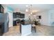 Modern kitchen featuring stainless steel appliances, black cabinetry, an island with bar seating, and dining table at 7869 Timberview Loop, Wesley Chapel, FL 33545