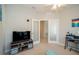 Office includes a large television, a desk area, and frosted glass doors to another room at 7869 Timberview Loop, Wesley Chapel, FL 33545