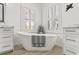 Elegant white soaking tub complemented by windows with shutters, creating a relaxing spa atmosphere at 819 Islebay Dr, Apollo Beach, FL 33572