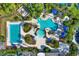 Aerial view of community pools surrounded by lounge chairs, palm trees and landscaping at 8420 Dunham Station Dr, Tampa, FL 33647