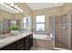 Bright bathroom featuring double vanity, soaking tub, and separate glass shower enclosure at 8420 Dunham Station Dr, Tampa, FL 33647
