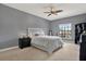 Relaxing bedroom featuring soft lighting, a ceiling fan, and a large window with tree view at 8420 Dunham Station Dr, Tampa, FL 33647