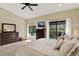 Bright bedroom featuring a cozy bed, dresser, and sliding glass doors to a balcony at 8420 Dunham Station Dr, Tampa, FL 33647