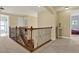 Bright hallway with wood and metal staircase banister, neutral walls, and open layout at 8420 Dunham Station Dr, Tampa, FL 33647