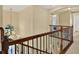 Hallway with chandelier and staircase featuring wooden railing with metal balusters at 8420 Dunham Station Dr, Tampa, FL 33647