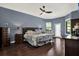 Spacious primary bedroom with hardwood floors, large windows, and a ceiling fan at 8420 Dunham Station Dr, Tampa, FL 33647