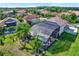 Back of home aerial view, highlighting a large screened pool area with mature palm trees and manicured landscaping at 8420 Dunham Station Dr, Tampa, FL 33647