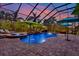 Lovely screened-in pool area with a relaxing spa, outdoor seating, and tropical landscaping at 8420 Dunham Station Dr, Tampa, FL 33647