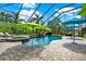 Enclosed pool area with spa and rock waterfall feature shaded by colorful umbrellas at 8420 Dunham Station Dr, Tampa, FL 33647