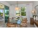 Bright dining room with a modern chandelier, glass table, stylish chairs, and large windows at 9740 Redwood Heights Loop, Thonotosassa, FL 33592