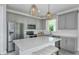 Modern kitchen featuring grey cabinets, stainless appliances, and a large center island at 9754 Redwood Heights Loop, Thonotosassa, FL 33592