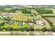 Aerial view of a lovely landscaped property nestled in a tranquil neighborhood with mature trees and a pond nearby at 9916 Preakness Stakes Way, Dade City, FL 33525