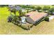 Aerial view of a backyard with a sparkling pool, tropical landscaping, and an outdoor sitting area with a fire pit at 9916 Preakness Stakes Way, Dade City, FL 33525