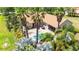 Aerial view of a backyard with a sparkling pool, screened patio, lush landscaping, and a dining set at 9916 Preakness Stakes Way, Dade City, FL 33525