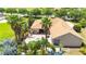 Aerial view of a backyard featuring a sparkling pool, brick patio, tropical landscaping, and outdoor seating at 9916 Preakness Stakes Way, Dade City, FL 33525