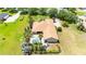 Aerial view of a backyard featuring a pool, lush landscaping, and patio area, surrounded by a well-maintained lawn at 9916 Preakness Stakes Way, Dade City, FL 33525