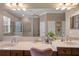 Bathroom vanity with dual sinks, a large mirror, decorative plants, and plenty of counter space at 9916 Preakness Stakes Way, Dade City, FL 33525