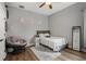 Cozy bedroom features hardwood floors, neutral walls, a comfortable chair, and plenty of light at 9916 Preakness Stakes Way, Dade City, FL 33525