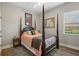 Bedroom with hardwood floors, a four-poster bed, neutral walls, and a window at 9916 Preakness Stakes Way, Dade City, FL 33525