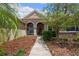 Charming home featuring an inviting front porch with stone accents and manicured landscaping at 9916 Preakness Stakes Way, Dade City, FL 33525