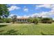 Charming single-story home with a well-manicured lawn, complemented by palm trees, shrubs, and mulch at 9916 Preakness Stakes Way, Dade City, FL 33525