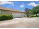 The large three-car garage features ample parking and a well-maintained driveway surrounded by mature trees and landscaping at 9916 Preakness Stakes Way, Dade City, FL 33525