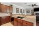 Well-lit kitchen boasts stone countertops, wood cabinets, modern faucet, and artwork, plus stainless steel appliances at 9916 Preakness Stakes Way, Dade City, FL 33525
