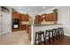 Open kitchen design with breakfast bar, tile floors, stainless steel appliances, and rich wood cabinetry at 9916 Preakness Stakes Way, Dade City, FL 33525
