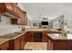 Kitchen with wood cabinets, granite countertops, and stainless steel appliances, offering a view to the living space at 9916 Preakness Stakes Way, Dade City, FL 33525