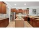 Spacious kitchen with wood cabinets, granite countertops, stainless steel appliances, and a center island at 9916 Preakness Stakes Way, Dade City, FL 33525