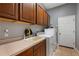 Laundry room with cabinets, a sink, washer and dryer, and a door to the outside at 9916 Preakness Stakes Way, Dade City, FL 33525
