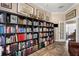 Elegant library featuring a wall of built-in bookshelves, and parquet wood floors at 9916 Preakness Stakes Way, Dade City, FL 33525