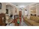 Spacious living room with hardwood floors, a cozy sofa, and direct access to the dining room and front entrance at 9916 Preakness Stakes Way, Dade City, FL 33525