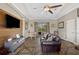 Open living area featuring hardwood floors, a TV accent wall, and comfortable lounge furniture at 9916 Preakness Stakes Way, Dade City, FL 33525