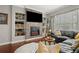 Inviting living room featuring a brick fireplace, built-in shelves, and comfortable leather sectional at 9916 Preakness Stakes Way, Dade City, FL 33525