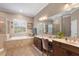 Luxurious bathroom featuring a soaking tub, walk-in shower, dual vanities, and natural light at 9916 Preakness Stakes Way, Dade City, FL 33525