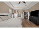 Spacious main bedroom with wood floors, panel molding, ensuite bath, and access to the library at 9916 Preakness Stakes Way, Dade City, FL 33525
