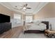 Inviting bedroom with tray ceiling, wood floors, and a sitting area near bright windows at 9916 Preakness Stakes Way, Dade City, FL 33525