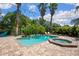 Backyard oasis featuring a sparkling pool, spa, brick patio, and lush tropical landscaping at 9916 Preakness Stakes Way, Dade City, FL 33525