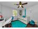 Light and airy bedroom with a daybed, fun turquoise accents, and a ceiling fan, creating a bright and inviting space at 4252 Sheldon Pl # 4252, New Port Richey, FL 34652