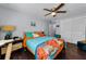 Comfortable bedroom with dark wood floors, ceiling fan, and ample natural light from a window, creating a cozy atmosphere at 4252 Sheldon Pl # 4252, New Port Richey, FL 34652