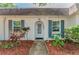 Close-up of front door showing a well-kept entryway with decorative mulch beds and painted window shutters at 4252 Sheldon Pl # 4252, New Port Richey, FL 34652